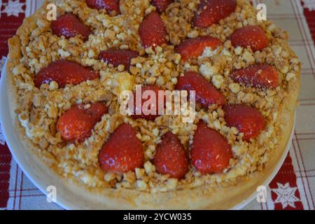 Kochen, köstliche hausgemachte Kuchen mit eigenen Händen. Ein brauner Mürbteig mit einer köstlichen, süßen Füllung und in Scheiben geschnittenen Erdbeeren. Stockfoto