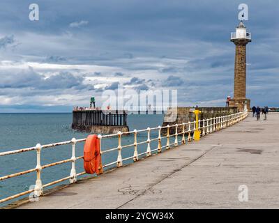 Whitby, North Yorkshire, mit Blick auf das Meer entlang des ursprünglichen, aus Stein gebauten Piers, der die Seeschützung für die Nordseite des Hafeneingangs bildet Stockfoto