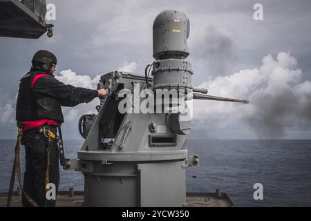 Gunner's Mate 3rd Class Patrick Applegate aus Loudoun County, Virginia, der der Waffenabteilung zugeteilt ist, feuert manuell eine Mark-38 ab Stockfoto