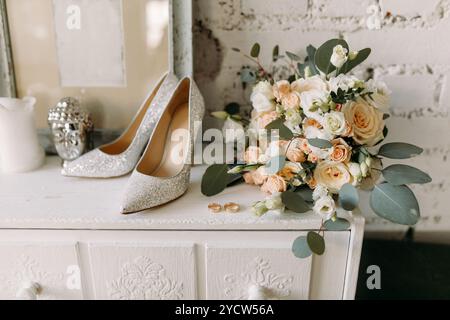 Hochzeitsschuhe und Utensilien auf einem weißen Tisch Stockfoto