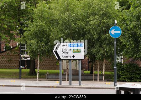 Leeds England: 4. Juni 2024: Wegweiser an einer Kreuzung mit Routen nach York, Skipton, Otley und einem Flughafen in einer grünen städtischen Umgebung Stockfoto