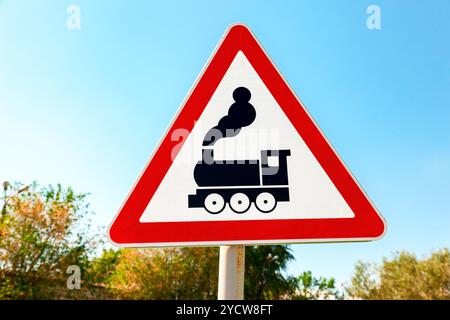 Verkehr-Warnschild mit Zug-Symbol vor dem blauen Himmelshintergrund Stockfoto