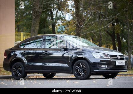 Minsk, Weißrussland - 22. Oktober 2024: Schwarzer Volkswagen Polo Limousine I, kompakte Limousine parkt, Ansicht von vorne rechts Stockfoto