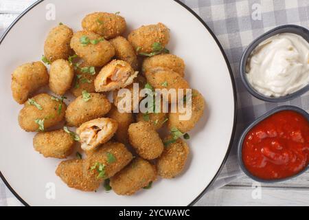 Frittierte panierte Muscheln, serviert mit Mayonnaise und Ketchup in Nahaufnahme auf einem Teller auf einem Tisch. Horizontale Draufsicht von oben Stockfoto