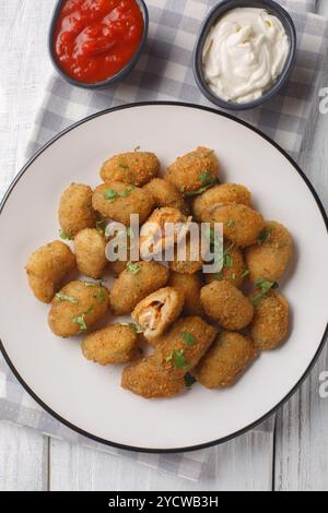 Vorspeise gebratene panierte Muscheln, serviert mit Mayonnaise und Ketchup in Nahaufnahme auf einem Teller auf dem Tisch. Vertikale Draufsicht von oben Stockfoto