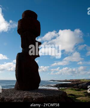 Einsame Moai-Steinstatue auf der Osterinsel, Rapa Nui, in Richtung Land. Ozean Hintergrund, blauer Himmel und Wolken. Kopierbereich Stockfoto