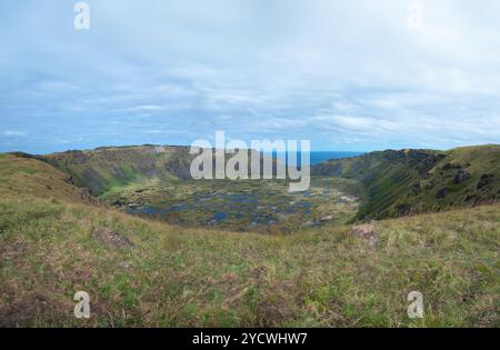 Der alte ruhende Vulkankrater Rano Kau auf der Osterinsel, Rapa Nui, Hintergrund des Ozeans, bewölkter Himmel Stockfoto