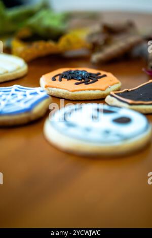 Hausgemachte Desserts zum Thema Halloween. Verschiedene Kuchen mit den Gesichtern verschiedener Monster der Halloween-Feiertage. Hintergrund mit Herbstle Stockfoto