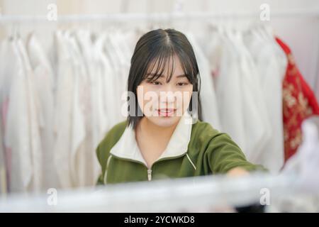 Ein koreanisches Paar, ein Mann in den 30ern und eine Frau in den 20ern, wählt harmonisch Kleidung für einen Hanbok-Verleih in Seoul, Südkorea. Stockfoto