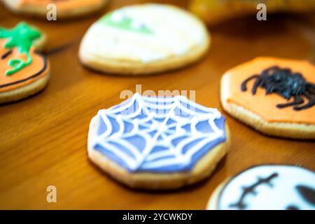 Hausgemachte Desserts zum Thema Halloween. Verschiedene Kuchen mit den Gesichtern verschiedener Monster der Halloween-Feiertage. Hintergrund mit Herbstle Stockfoto