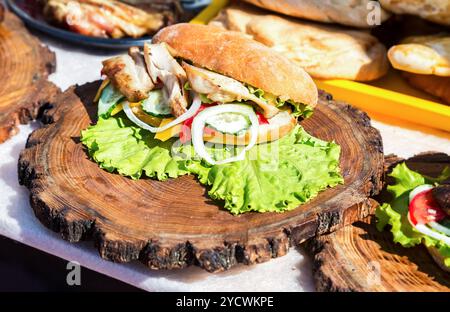 Burger mit Hähnchenfleisch, Käse und frisches Gemüse auf Holzbrett. Einfache Idee für vegetarische sandwich Stockfoto