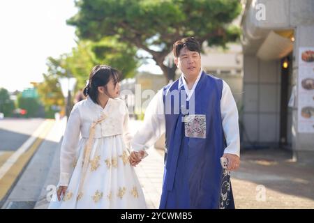 Ein koreanisches Paar, ein Mann in den 30ern und eine Frau in den 20ern, läuft harmonisch auf einer öffentlichen Straße mit Hanbok in Seoul, Südkorea. Stockfoto