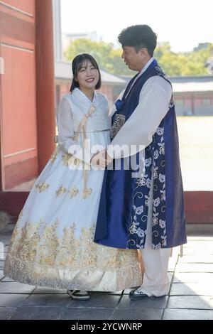 Ein koreanisches Paar, ein Mann in den 30ern und eine Frau in den 20ern, wird in einem historischen Gebäude in Seoul, Südkor, gesehen, wie sie sich mit Hanbok anschauen Stockfoto