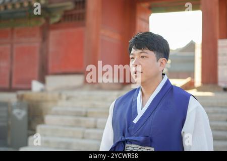 Ein koreanisches Paar, ein Mann in den 30ern und eine Frau in den 20ern, geht harmonisch durch ein historisches Gebäude in Seoul, Südkorea, mit Hanbok. Stockfoto