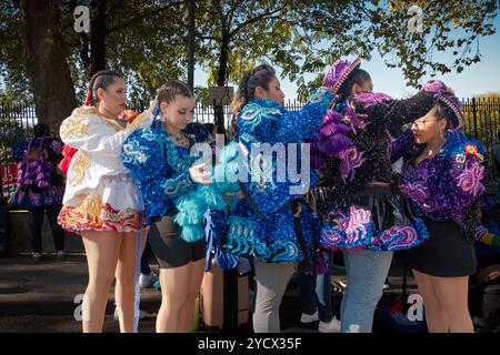 5 Mädchen aus der San Simon Tanzgruppe passen ihre Haare und Kostüme vor der Bolivian Day Parade 2024 in Jackson Heights, Queens, New York an. Stockfoto