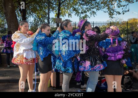 5 Mädchen aus der San Simon Tanzgruppe passen ihre Haare und Kostüme vor der Bolivian Day Parade 2024 in Jackson Heights, Queens, New York an. Stockfoto