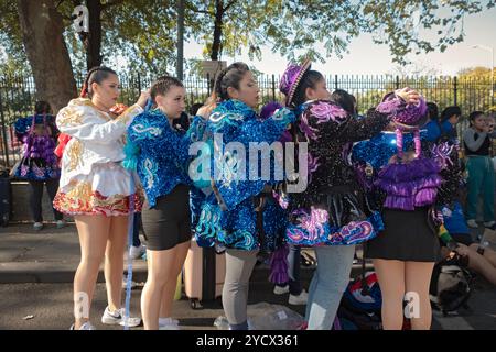 5 Mädchen aus der San Simon Tanzgruppe passen ihre Haare und Kostüme vor der Bolivian Day Parade 2024 in Jackson Heights, Queens, New York an. Stockfoto