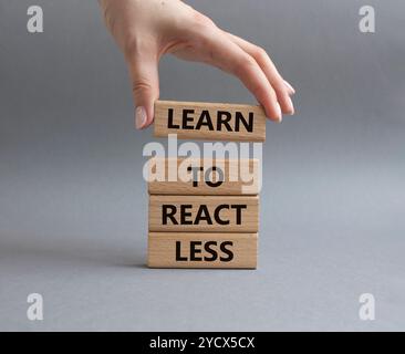 Lernen Sie, weniger zu reagieren Symbol. Holzblöcke mit Worten lernen, weniger zu reagieren. Geschäftsmann Hand. Schöner grauer Hintergrund. Unternehmen und lernen, Les zu reagieren Stockfoto