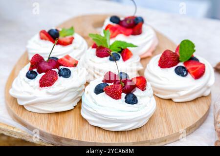 Süße Kuchen mit frischen Beeren, die auf der Holzschale liegen Stockfoto