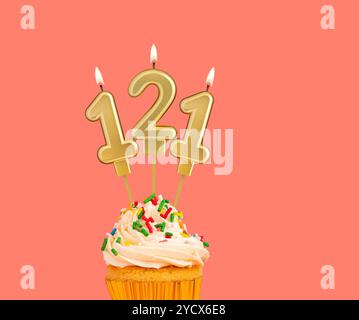 Geburtstagsnummer 121 - Goldene Kerze mit Cupcake Stockfoto