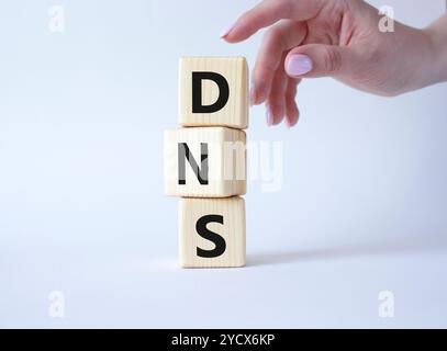 DNS -Domain Name Server - Symbol für Verbraucherpreisindex. Konzeptwort DNS auf Holzwürfeln. Geschäftsmann Hand. Schöner weißer Hintergrund. Business und DN Stockfoto