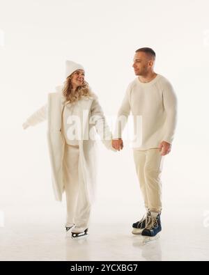 Die Familie hält die Hände, um die Freude am Winter zu genießen, während der Feiertage gemeinsam auf Eis vor weißem Studio-Hintergrund zu feiern. Stockfoto
