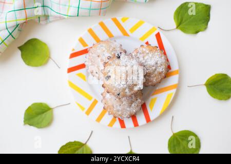 Farbige Cupcakes auf einem Teller mit grünen Blättern und Handtuch Stockfoto