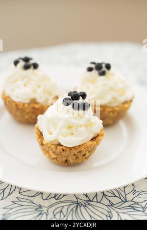 Hausgemachte Muffins mit Blaubeeren, Sahne und frischen Beeren auf einer Serviette Stockfoto