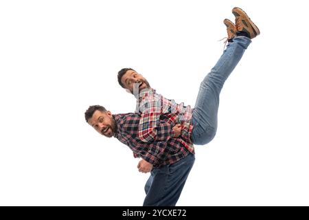 Zwei Brüder, Zwillinge, dazu passende Freizeitoutfits, Spaß haben, fröhliche und unterstützende Momente gemeinsam vor weißem Studiohintergrund teilen Stockfoto