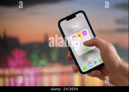 Hannover, Deutschland. Oktober 2024. ABBILDUNG - Eine Frau hält ein Smartphone, auf dem die Dating-Apps Tinder, Bumble, OkCupid und Scharnier angezeigt werden. Quelle: Alicia Windzio/dpa/Alamy Live News Stockfoto