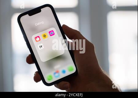 Hannover, Deutschland. Oktober 2024. ABBILDUNG - Eine Frau hält ein Smartphone, auf dem die Dating-Apps Tinder, Bumble, OkCupid und Scharnier angezeigt werden. Quelle: Alicia Windzio/dpa/Alamy Live News Stockfoto