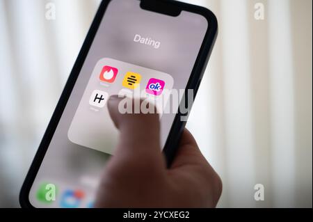 Hannover, Deutschland. Oktober 2024. ABBILDUNG - Eine Frau hält ein Smartphone, auf dem die Dating-Apps Tinder, Bumble, OkCupid und Scharnier angezeigt werden. Quelle: Alicia Windzio/dpa/Alamy Live News Stockfoto