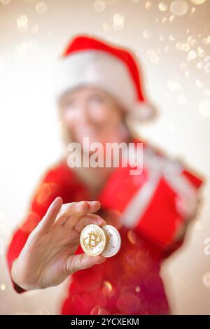 Sydney, Australien - 17. Dezember 2017; Verwendung von Kryptowährung zum Kauf von Geschenken und Geschenken zu Weihnachten. Eine Frau hält einen Bitcoin und einen litecoin in der Hand Stockfoto