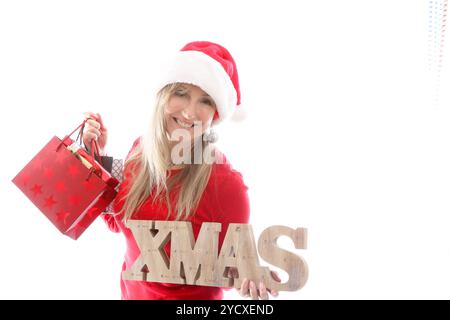 Frau mit Weihnachtsschild und Einkaufstaschen Stockfoto