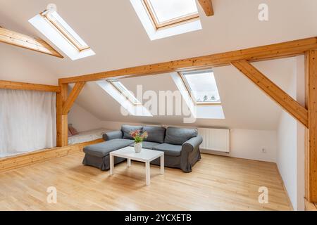 Geräumiges, helles Wohnzimmer im Dachgeschoss mit Holzbalken Stockfoto