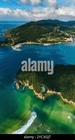 Atemberaubendes, von Drohnen aufgenommenes Bild, das die lebendigen grünen Landschaften und das kristallklare Wasser entlang der Küste Galiciens zeigt, die das Foto dicht zeigt Stockfoto