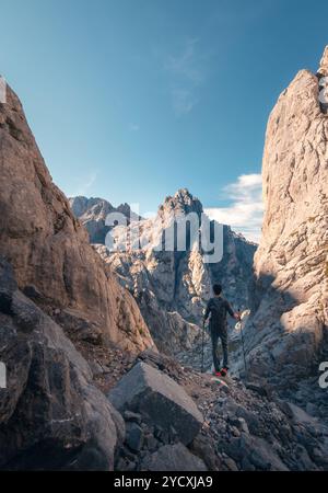 Rückblick auf unerkennbare Wanderer führt über einen zerklüfteten Pfad in Richtung Collado Jermoso Refuge inmitten der majestätischen Picos de Europa. Stockfoto