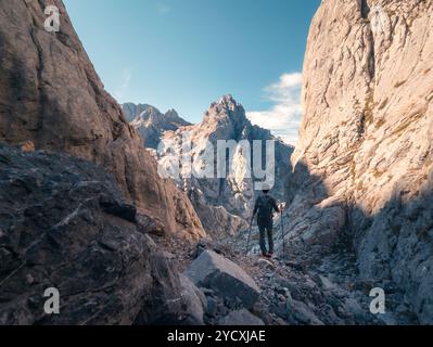 Rückblick auf unerkennbare Wanderer führt über einen zerklüfteten Pfad in Richtung Collado Jermoso Refuge inmitten der majestätischen Picos de Europa. Stockfoto