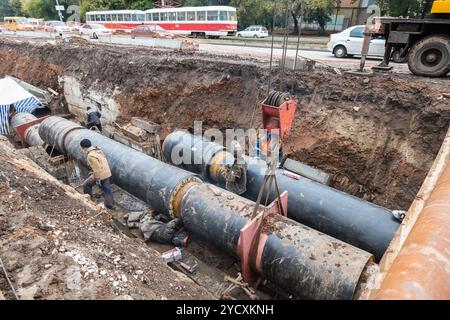 Samara, Russland - Oktober 1, 2017: Reparatur der Heizungsleitung. Die Arbeiter, Schweißer von elektrischem Schweißen an großen Eisen Rohre in einer Tiefe von excavat Stockfoto