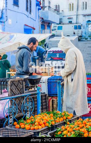 Chefchaouen, Marokko - 8. Dezember: Mann Kommissionierung Orangen auf dem lokalen Markt in Lima. Dezember 2016 Stockfoto