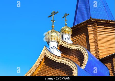 Goldenen Kuppeln mit Kreuzen auf hölzernen orthodoxen Kirche gegen den blauen Himmel in Samara, Russland Stockfoto