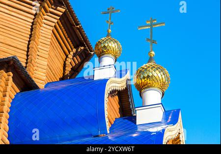 Goldenen Kuppeln mit Kreuzen auf hölzernen orthodoxen Kirche gegen den blauen Himmel in Samara, Russland Stockfoto