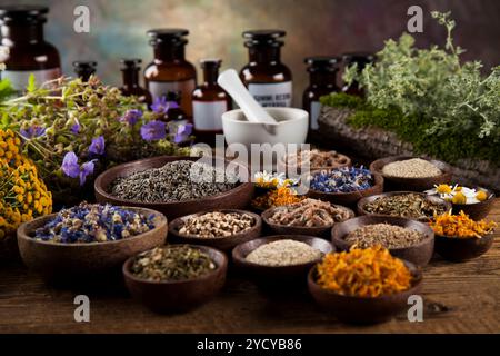 Kräuter, Beeren und Blumen mit Mörtel, Holz Tisch Hintergrund Stockfoto