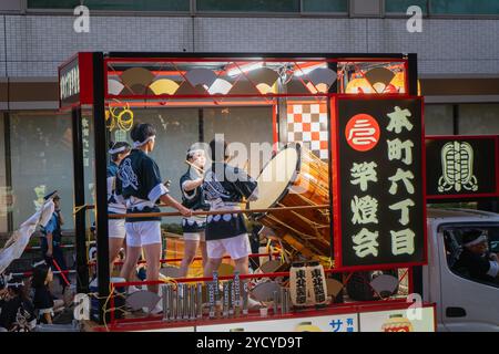 Akita, Japan – 5. August 2024: Junge Frauen spielen Taiko-Schlagzeug und Flöten auf einem Festwagen während des Akita Kanto Festivals. Die Menge jubelte und beschimpfte Stockfoto