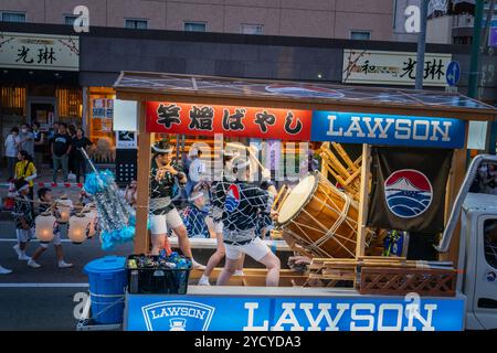 Akita, Japan – 5. August 2024: Junge Frauen spielen Taiko-Schlagzeug und Flöten auf einem Festwagen während des Akita Kanto Festivals. Die Menge jubelte und beschimpfte Stockfoto