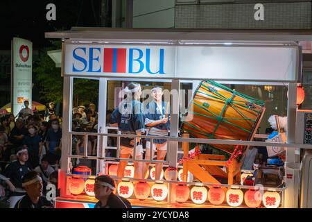 Akita, Japan – 5. August 2024: Junge Frauen spielen Taiko-Schlagzeug und Flöten auf einem Festwagen während des Akita Kanto Festivals. Die Menge jubelte und beschimpfte Stockfoto