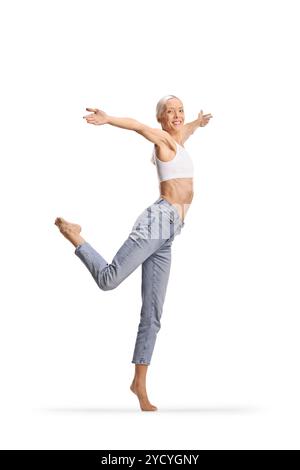 Große schlanke Frau in Jeans und weißem Crop Top, das modernes Ballett auf weißem Hintergrund tanzt Stockfoto