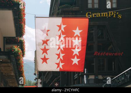 Zermatt, Schweiz - 27. Juli 2024: Die Walliser Flagge hängt über den Straßen des Dorfes Zermatt Stockfoto