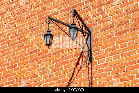 Alte dekorative Bügeleisen street lamp hängen an den verwitterten Mauer Stockfoto