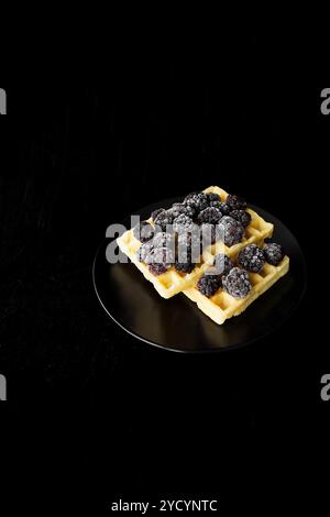 Belgische Waffeln mit Gefrorene Brombeeren auf schwarzem Hintergrund Stockfoto